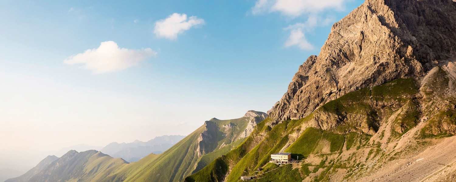 Das Waltenbergerhaus ist eingebettet in eine alpine Graslandschaft