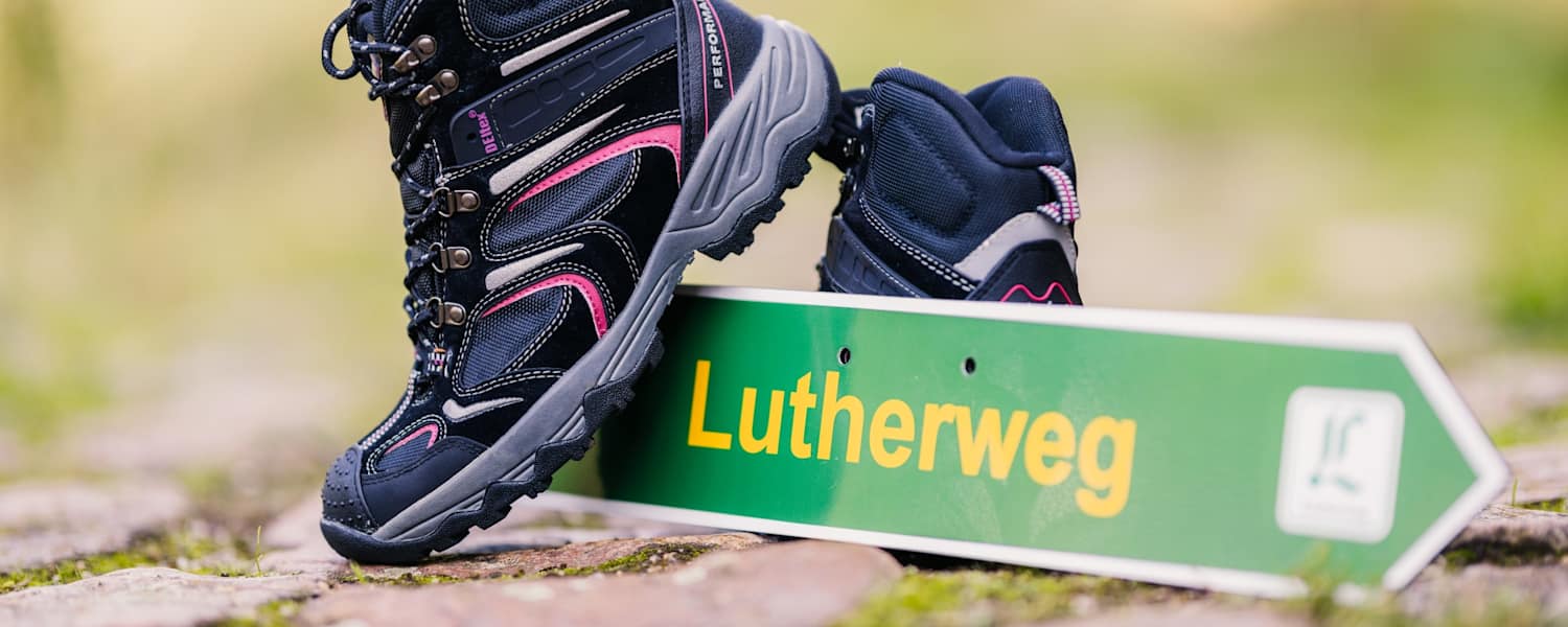 Lutherweg Sachsen Schild und Wanderschuhe