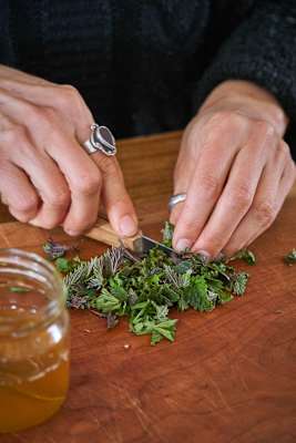 Frau beim Zerkleinern von Kräutern