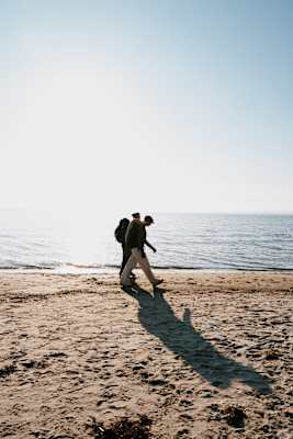 Zwei Wanderer auf einem Sandstrand auf Rügen.