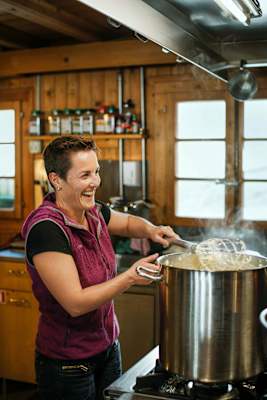 Die Hüttenwartin bekocht ihre Gäste.