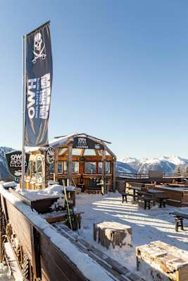 Auf der Sonnenterrasse weht die Fahne von Onkel Willy's Hütte mit dem unverkennbaren Logo.