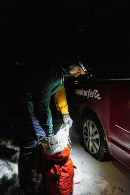 Bergsteiger in der Nacht beim Packen seines Rucksacks