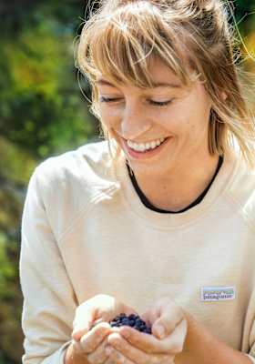 Der Kletterer isst frisch gepflückte Heidelbeeren, um sich zu stärken.