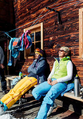 Kathrin und Eva genießen die Sonne auf der Hausbank der urigen Hütte