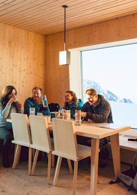 Wanderer sitzen in einer Almhütte.