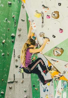 Ein Kind klettert in der Kletterhalle.