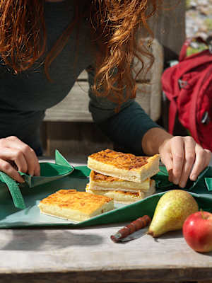 Frau beim Anrichten einer Käsewähe