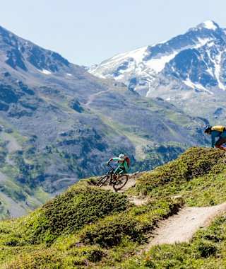 Mountainbiker auf dem Corviglia Flow Trail mit Blick auf den Piz Corvatsch (3.451 m)