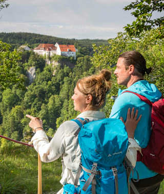 Wanderer am Bandfelsen mit der Burg Wildstein