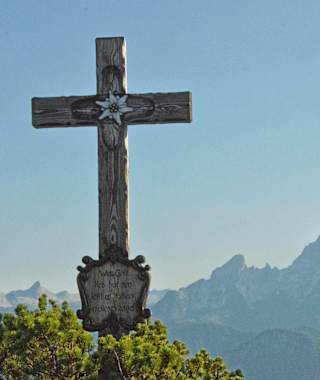 Gipfelkreuz auf der Kneifelspitze mit dem Watzmann im Hintergrund.