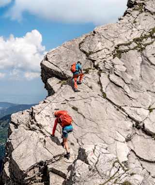 Auf den abschüssigen, glatten Festplatten am Hindelanger Klettersteig erleichtern Eisentritte den Aufstieg.