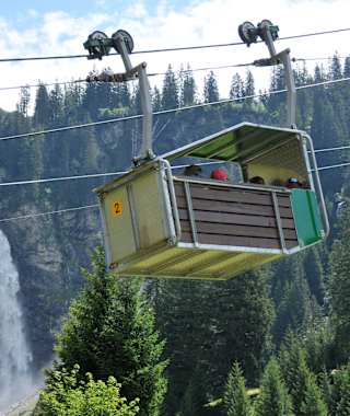 Die Luftseilbahn von Äsch zur Oberalp mit dem Stäubiwasserfall im Hintergrund