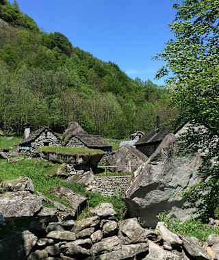 Der Wanderweg im Val Calneggia führt an typischen Steinhütten vorbei.