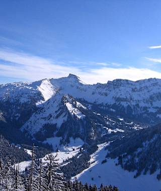 Der Hohe Ifen als Zacken in der Bildmitte. Die Abfahrt verläuft nach links dem Grat entlang und dann abwärts in die sonnenbeschienen Hänge