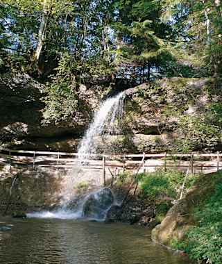 Unter dem kleinsten der drei Wasserfälle führt ein Weg entlang.