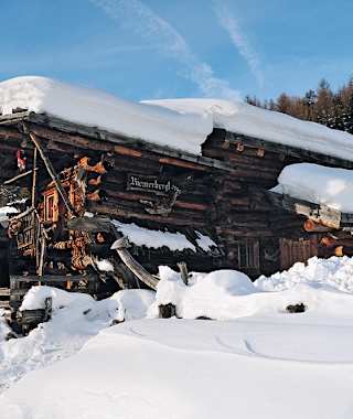 Hundertjähriges Holz eingebettet in das vergängliche Weiß der Winterlandschaft.