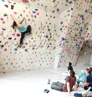 Eine Sportkletterlehrerin ist für Ausbildung und Training beim Bouldern und Vorstiegsklettern qualifiziert. 