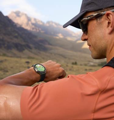 Outdoor-Sportler blickt auf seine HUAWEI WATCH GT 6 – präzises GPS-Tracking beim Laufen in den Bergen.
