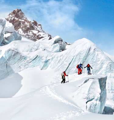 Die Gruppe vor einem imposanten Gletscherabbruch bei strahlend blauen Himmel.