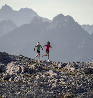 Zwei Frauen laufen über einen Berg