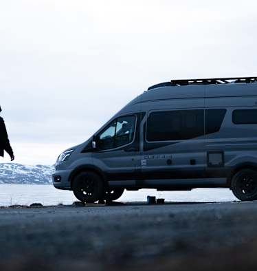 Ein Sunlight Camper steht vor einem See.