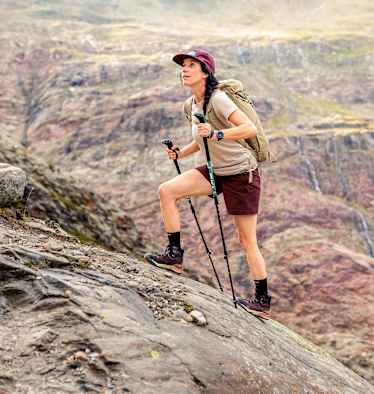 Eine Outdoor-Enthusiastin geht einen Fels hoch und trägt dabei den den LOWA® EXPLORER GTX MID Ws.