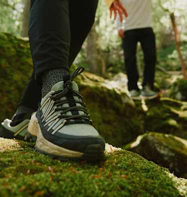 Der Wild Hike Wanderschuh von Jack Wolfskin auf bemoostem Stein in Wald.