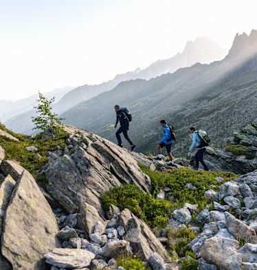 Zwei Männer und eine Frau gehen eine Tour auf einem panoramareichen Weg und tragen dabei den Ducan III Low LTH GTX.
