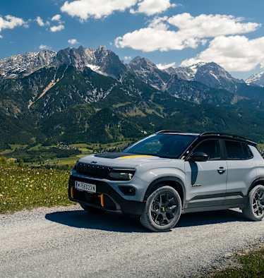 Der Jeep Avenger 4xe the North Face Edition vor einer Bergkulisse.