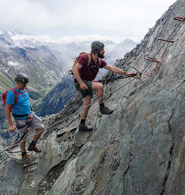 Zwei Kletterer steigen auf den Mittaghorn Klettersteig im Saastal.