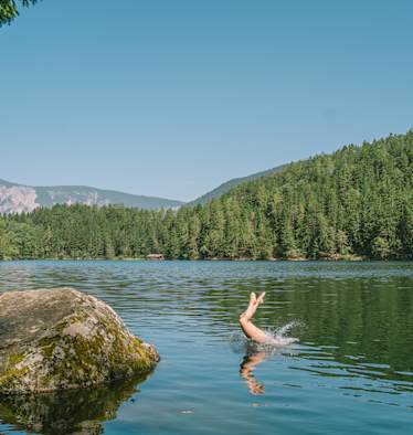 Eine Person springt in den Pitburger See in Tirol