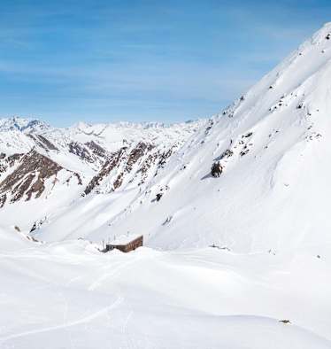 Die moderne Hütte schmiegt sich in die alpine Landschaft.