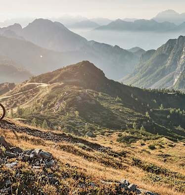 Abwärts in sanftem Licht: Mountainbiken mit Panoramablick.