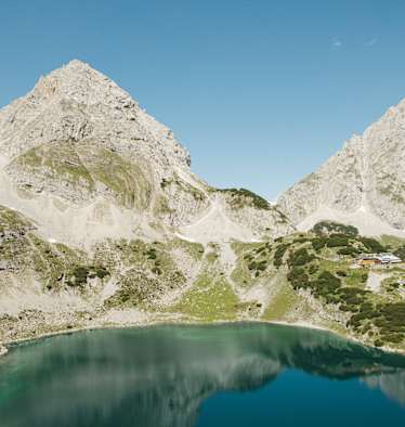 Der Drachensee im Mieminger Gebirge mit der Coburger Hütte an seinem Ufer.