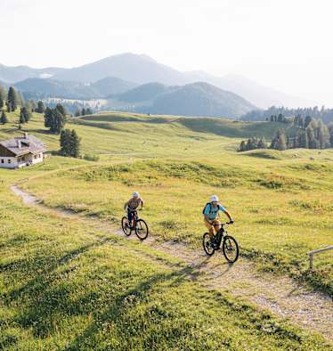 E-Mountainbiker bei der Gampenalm am Fuß der Geislerspitzen, Südtirol