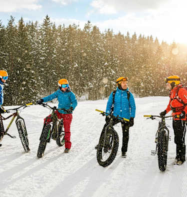 Die Fatbike-Gruppe bei strahlendem Sonneschein im Schnee.