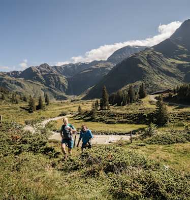 Zwei Wanderer mit Baby stapfen durch das Gasteinertal.