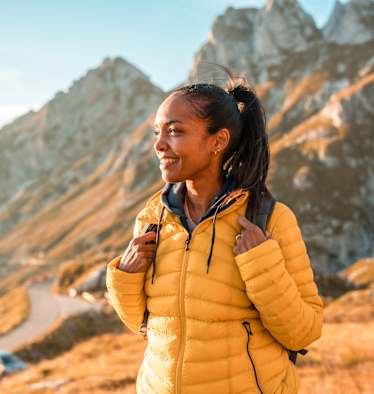frau in den bergen beim wandern genießt den ausblick im herbst