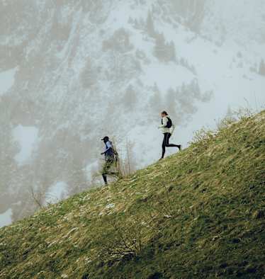 Zwei Trailerunner laufen mit der neuen Salomon Kollektion den Berg hinab.