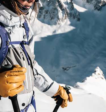 Freeriderin mit Therm-ic Freeride Ultra Heat Lederhandschuhen in verschneiter alpiner Berglandschaft – optimaler Schutz und Wärme bei eisigen Temperaturen.