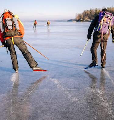Zwei Nordic Skater mit Rucksäcken auf einem gefrorenen See nahe Uppsala 