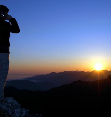 Notfall am Berg: Person im Gebirge am Handy