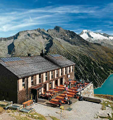 Die Olpererhütte besitzt einen Logenplatz über dem Schlegeis-Stausee. Dahinter Greinerkamm und der vergletscherte Möseler.