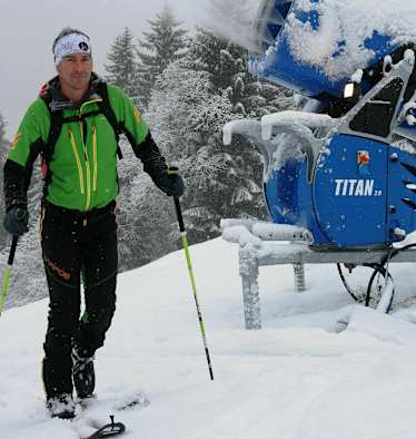 Skitourengeher im Skigebiet auf präparierter Piste