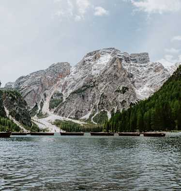 Pragser Wildsee mit Seekofel und Booten auf dem Wasser.