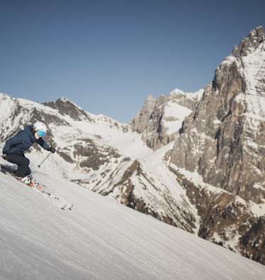 Schifahren in Ladurns in Südtirol mit Bergmassiv im Hintergrund.