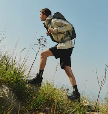 Ein Mann mit Wanderschuhen von Salomon auf dem Weg zum Ziel.
