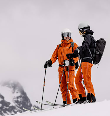 Zwei Personen auf dem Berg mit Ski und Ausrüstung von Skinfit.
