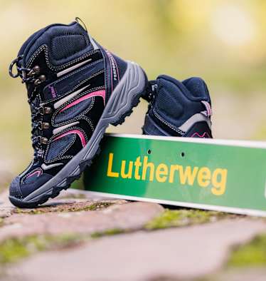 Lutherweg Sachsen Schild und Wanderschuhe